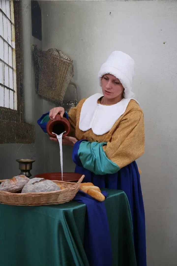 Vrouw in historisch kostuum als het Melkmeisje